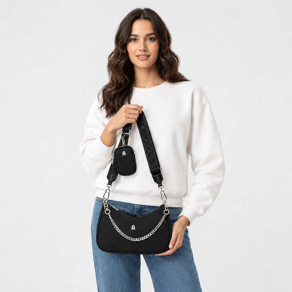 «Model houdt de Steve Madden Bdiego-H zwarte damestas met zilveren ketting vast in de hand, foto van taille omhoog»