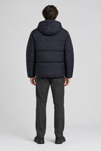Mannelijk model met de donkere Ellesse Puffer Jas Pollas met capuchon, volledig van achteren gefotografeerd
