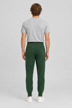 Mannelijk model met de groene About You Joggingbroek Taylan, volledig van achteren gefotografeerd