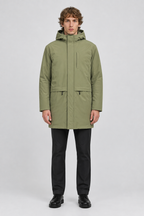 Mannelijk model met de lichtolijfgroene Blend Parka Ferdinan met capuchon, volledig van voren gefotografeerd