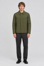 Mannelijk model met de olijfgroene Dan Fox Apparel Jas Edward met verticale stiksels, volledig van voren gefotografeerd