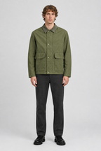 Mannelijk model met de olijfgroene Jack & Jones Utility Jas River met contrasterende kraag en klepzakken, volledig van voren gefotografeerd