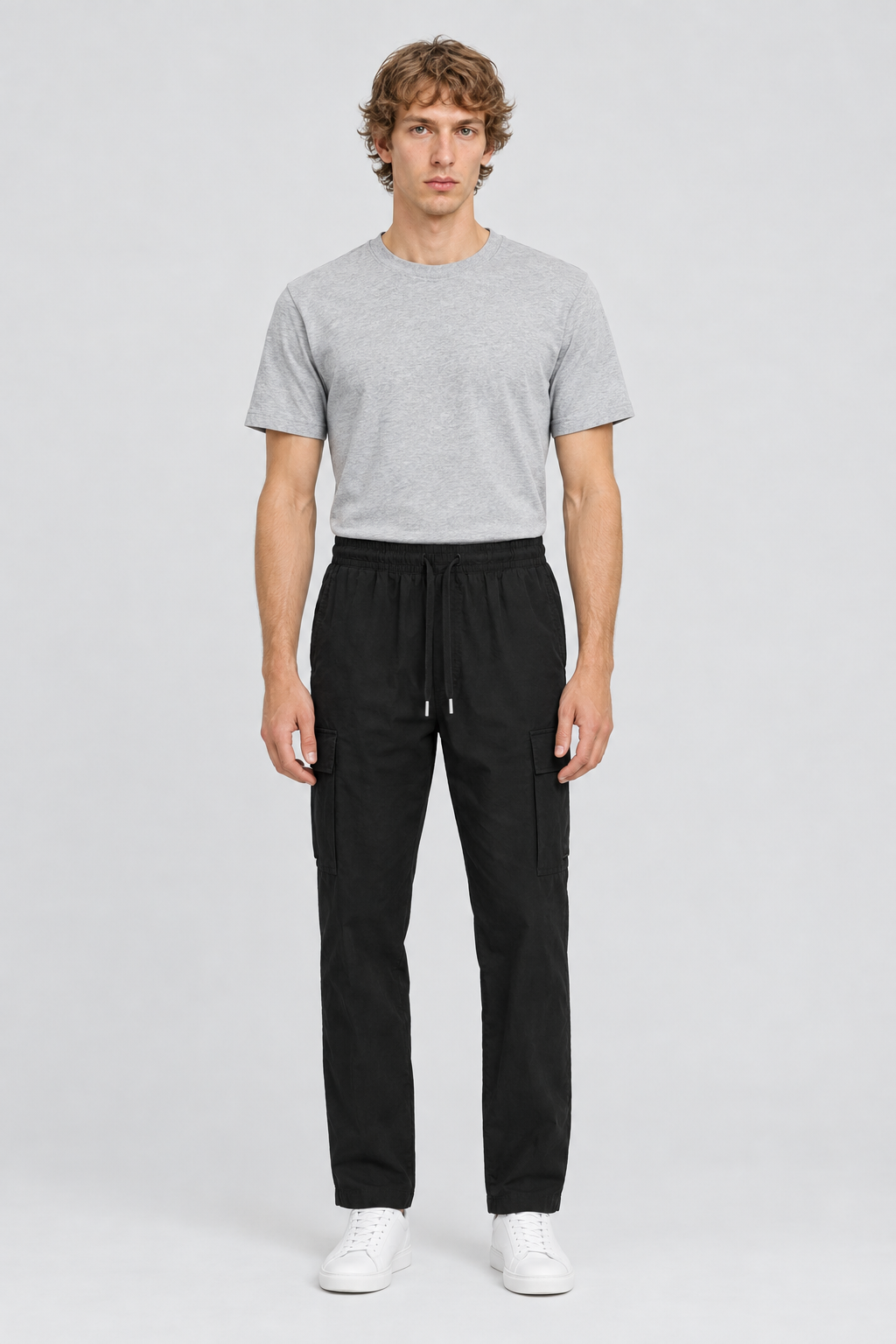 Mannelijk model met de zwarte Jack & Jones Cargobroek Karl Summer en een lichtgrijs T-shirt, volledig van voren gefotografeerd