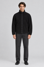 Mannelijk model met de zwarte Weekday Fleece Jas Kalix met opstaande kraag, volledig van voren gefotografeerd