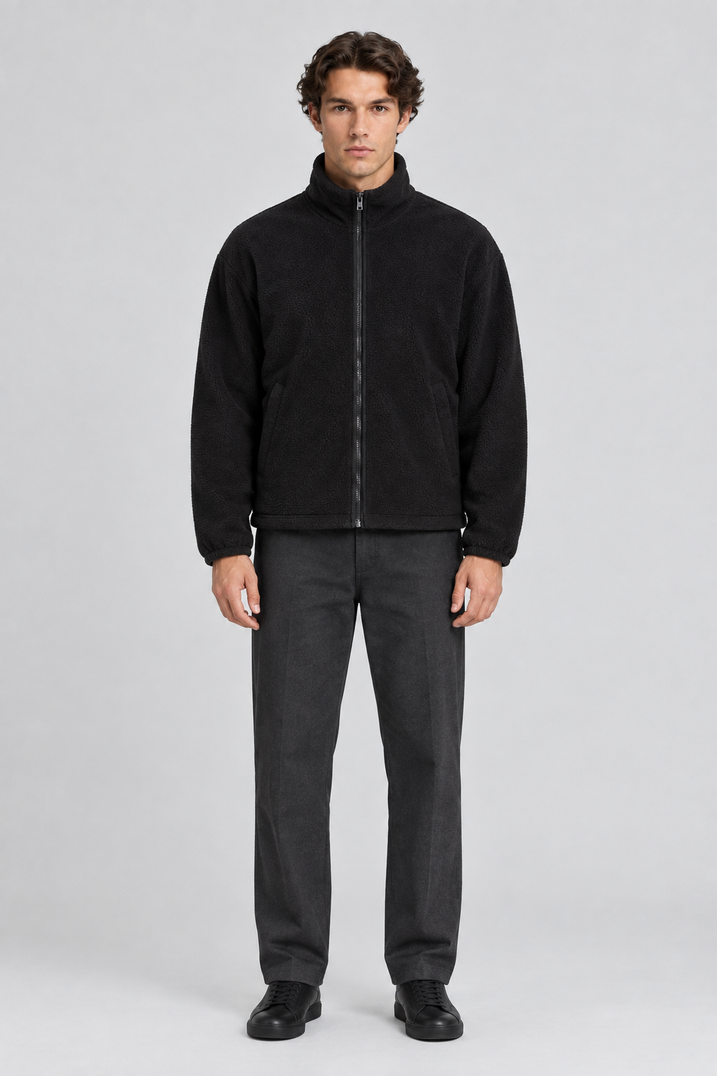 Mannelijk model met de zwarte Weekday Fleece Jas Kalix met opstaande kraag, volledig van voren gefotografeerd