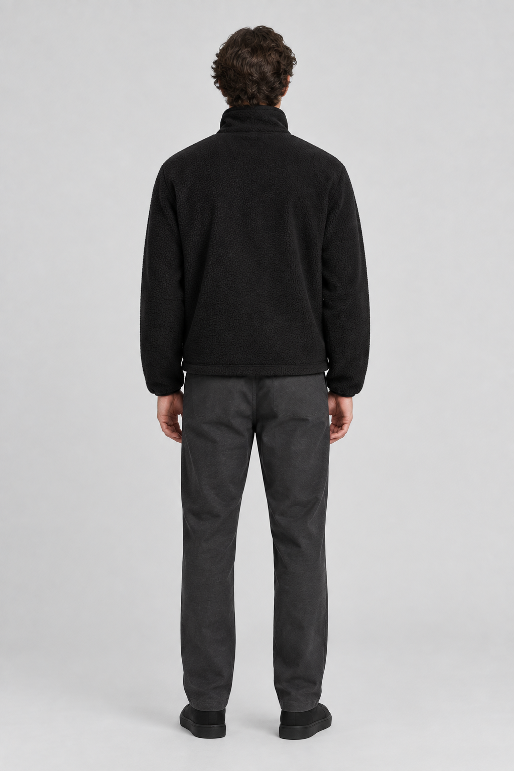 Mannelijk model met de zwarte Weekday Fleece Jas Kalix, volledig van achteren gefotografeerd