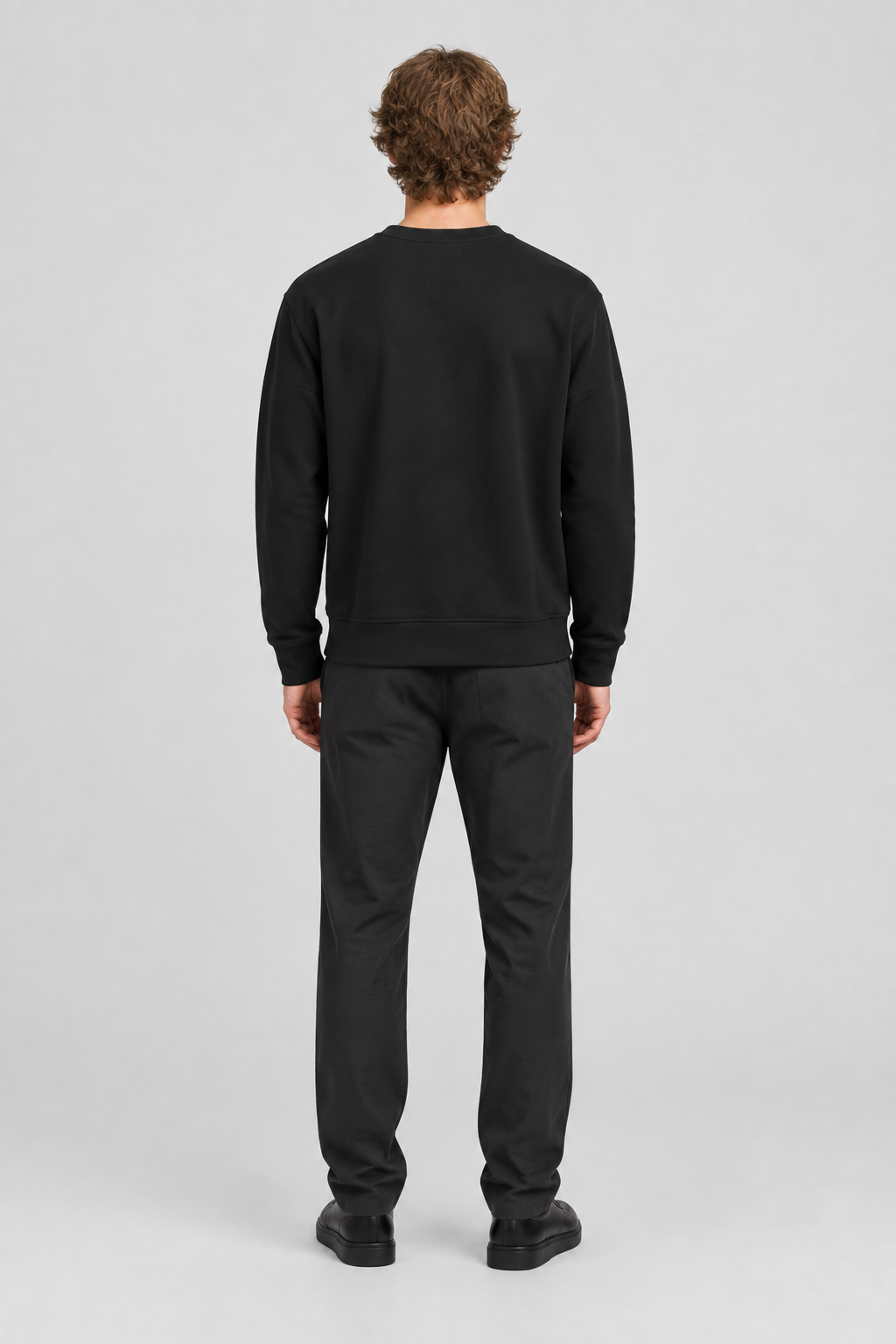 Mannelijk model met het zwarte About You GOTS Sweatshirt Ricardo, volledig van achteren gefotografeerd
