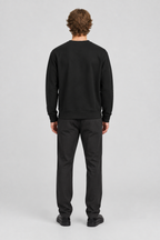 Mannelijk model met het zwarte About You GOTS Sweatshirt Ricardo, volledig van achteren gefotografeerd