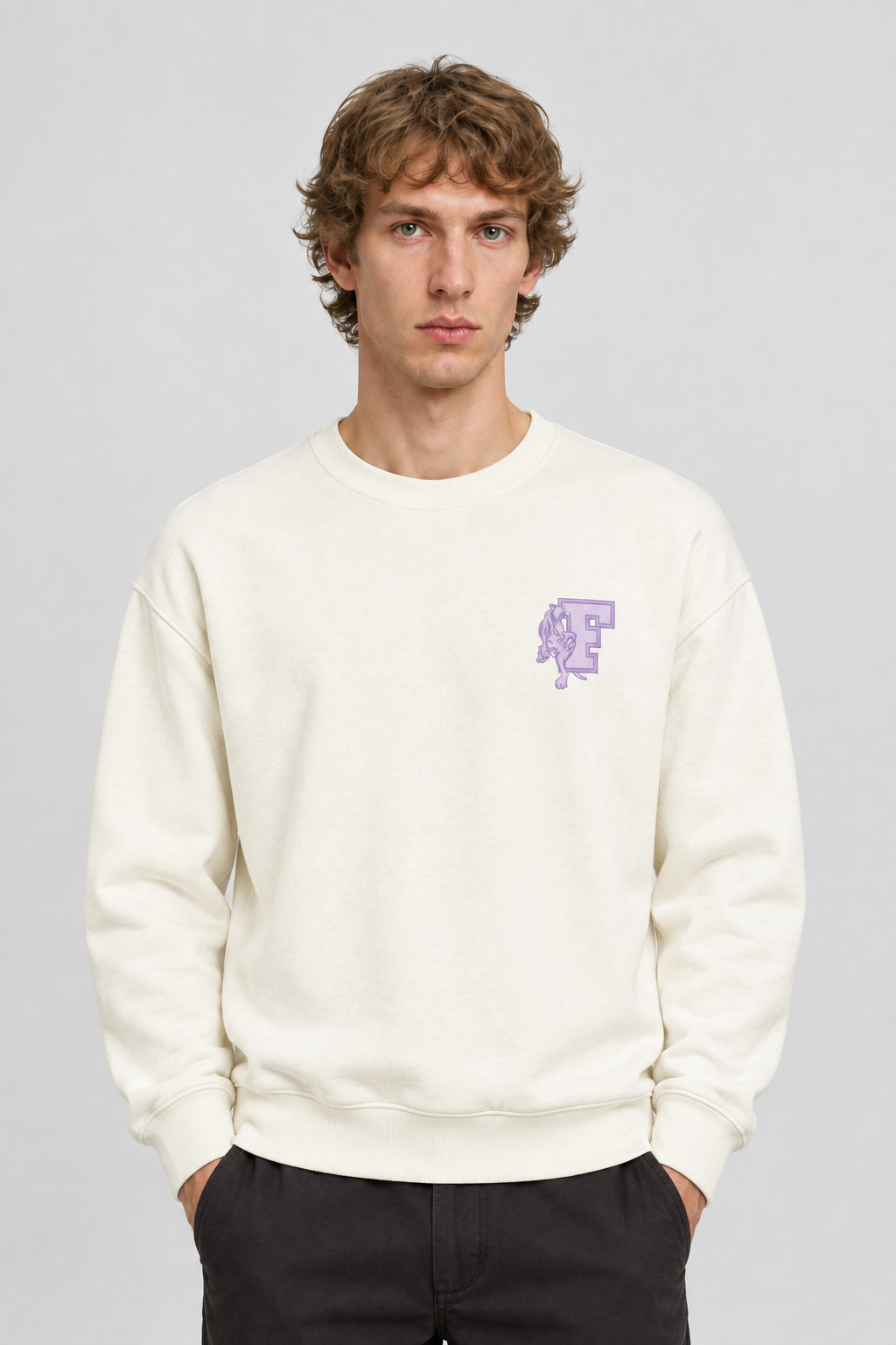 Vooraanzicht van een mannelijk model met de crèmekleurige Dan Fox Apparel Sweater Jesper met klein paars borstmotief